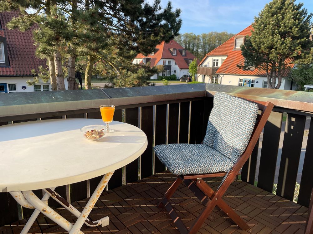 Der sonnenbeschienene Balkon mit einem Glas Wein